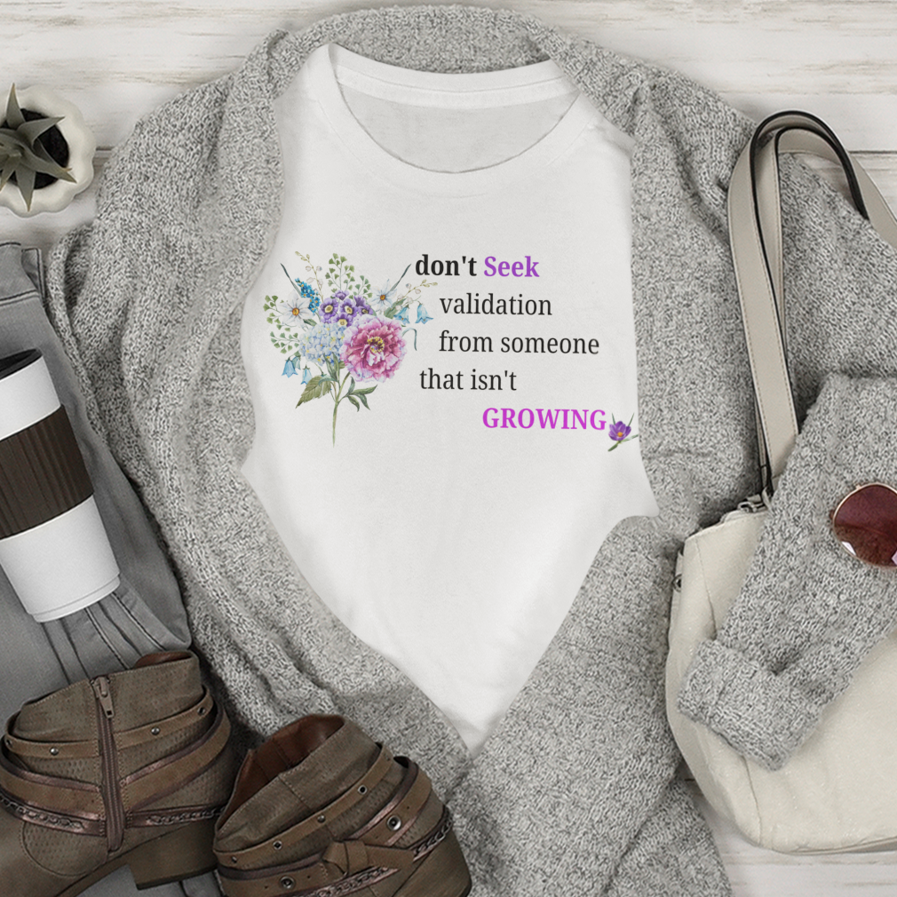 Flat lay of casual outfit with t-shirt, jeans, boots, and handbag on a wooden surface