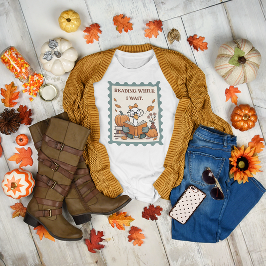 Reading While I Wait t-shirt with goose reading a book, pumpkins, and fall leaves